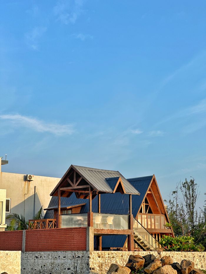 Charming A-frame house with rustic design under a clear blue sky, perfect for vacation getaways.
